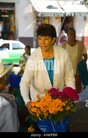 MEXICO Guanajuato Woman buying bouquet of flowers from street vendor Day of the Dead celebration Stock Photo