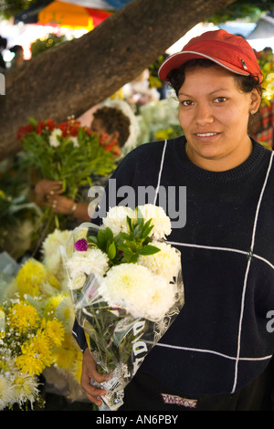MEXICO Guanajuato Woman holding bouquet of flowers street vendor white carnations for Day of the Dead celebration Stock Photo