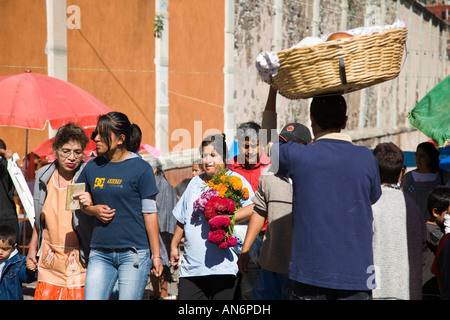 MEXICO Guanajuato People walking along street to cemetery carrying bouquets of flowers Day of the Dead Stock Photo