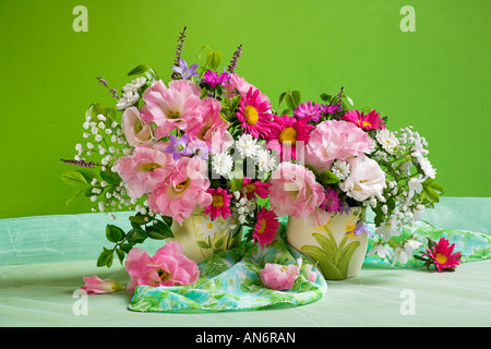 Studio arranged colorful bunch bouquet of pink anemones flowers in a vase on a pastel green background Stock Photo