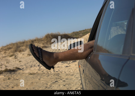 feet sticking out of the car window Stock Photo