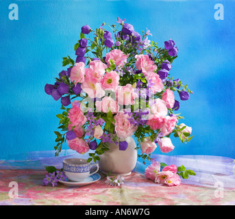 Studio arranged colorful bunch bouquet of pink anemones in a vase on a pastel blue background Stock Photo