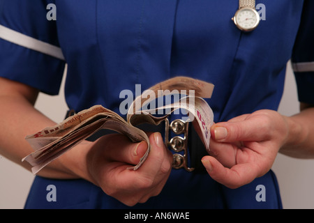 Nurse wearing blue uniform counting her money wages Stock Photo