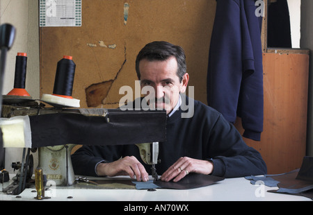 shoe maker using sewing machine to make shoes for editorial use only Stock Photo