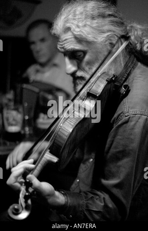 Celtic Tunes A pony tailed fiddle player in a traditional Irish pub Stock Photo