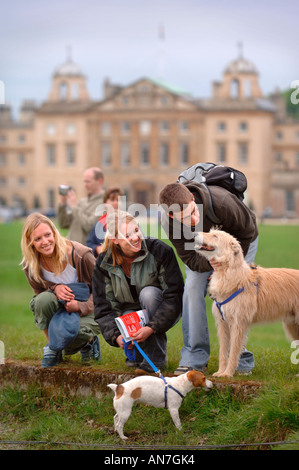 TWO TEENAGE GIRLS AND A BOY PLAYING WITH THEIR DOGS NEAR THE POND AT BADMINTON HORSE TRIALS 2006 UK Stock Photo