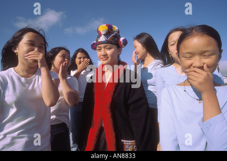 13 year old Asian girl in 'native clothes' encircled by a group of Asian girls in western clothes Stock Photo