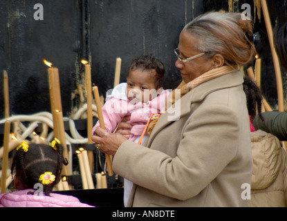 FATIMA PORTUGAL Black woman holding grandchild lights candle for her special intention at this world famous pilgrimage site Stock Photo