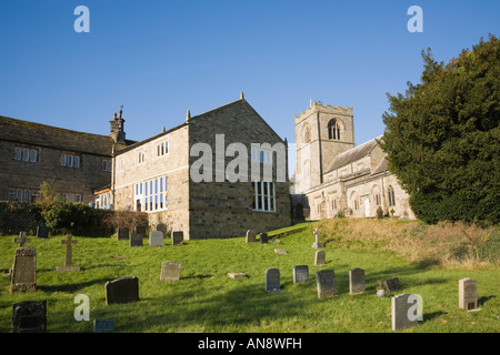 St Wilfrid's 16th century church graveyard beside 17th century Burnsall V A Primary School rear view Burnsall Yorkshire England UK Stock Photo