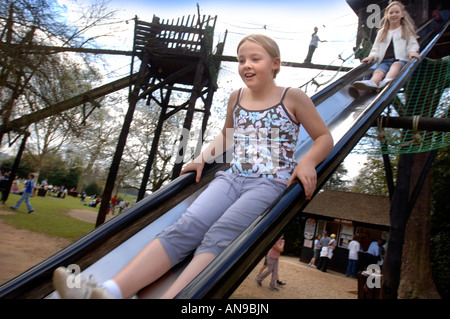 TWO GIRLS ON A SLIDE IN THE ADVENTURE PLAYGROUND AT BOWOOD HOUSE WILTSHIRE UK Stock Photo