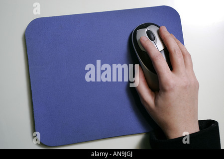 A HAND WITH MOUSE ON A MOUSEMAT . Stock Photo