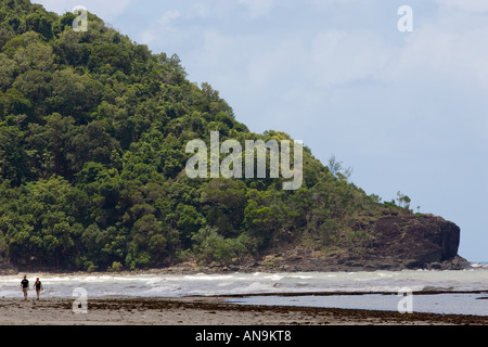 A couple walk along Myall Beach by Cape Tribulation named by Captain Cook Queensland Australia Stock Photo