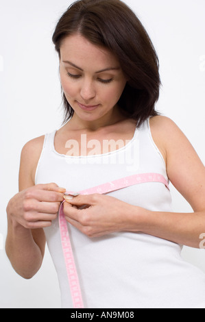 woman taking her bust measurement with a tape Stock Photo
