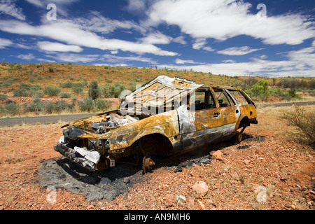 Burnt out car wreck on road from Alice Springs Namatjira Drive Northern Territory Australia Stock Photo