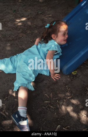 Crying child at the bottom of the slide at nursery school Stock Photo