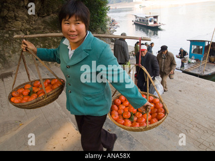 China Guangxi Yangshuo area Xingping local dock local female farmer carrying tomatoes Stock Photo