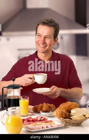 MAN HAVING BREAKFAST AND DRINKING COFFEE Stock Photo