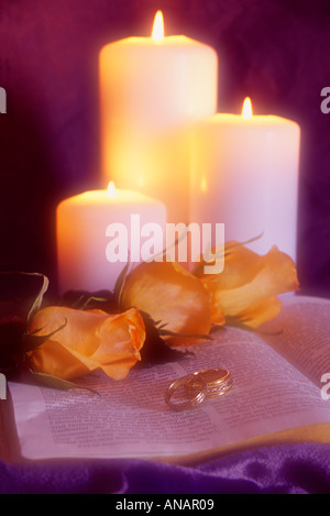 Still Life of Dreamy Effect on Wedding Rings, Bible, Candles, and Roses Stock Photo