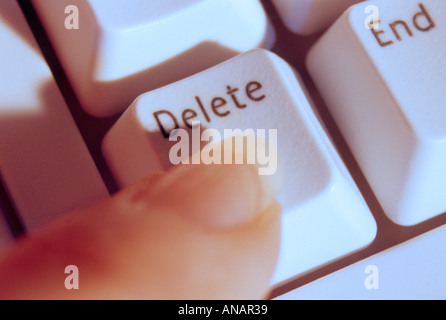 Finger pointing to the delete key on keyboard Stock Photo