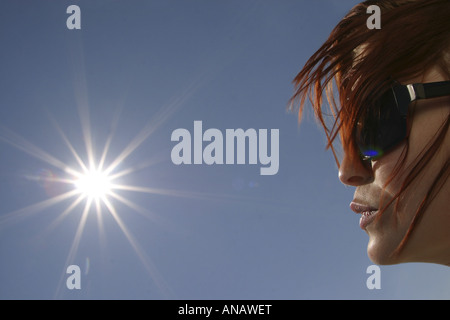 sun and side-face of a young redheaded woman Stock Photo