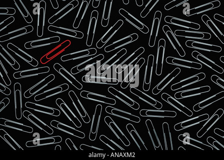 Paper Clips Against a Black Background All Silver with the Exception of One Red Clip Stock Photo