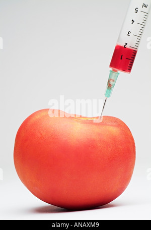 Syringe Injecting a Tomato Stock Photo
