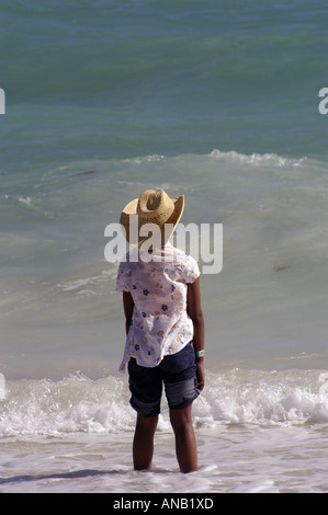 Bahamas Bahamian girl in straw hat dancing in surf Stock Photo