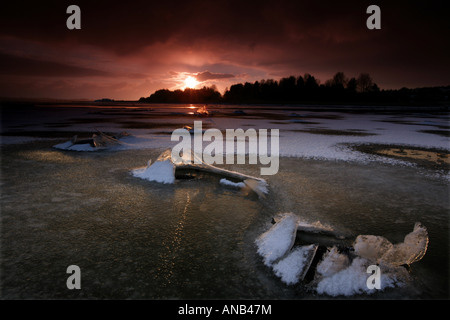 Cracked ice and sunset in Kurefjorden nature reserve, Rygge kommune, Østfold fylke, Norway. Stock Photo