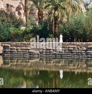 Egypt Luxor Karnak Temple view across the sacred lake with man in traditional dress Stock Photo