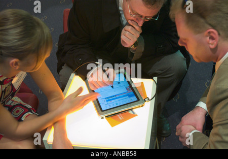 two men and a woman working with tablet PC Stock Photo