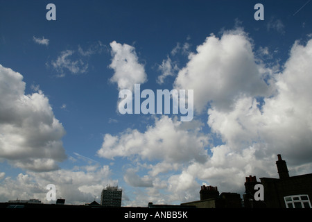 Fluffy white clouds on a blue sky over a London skyline in England UK Stock Photo
