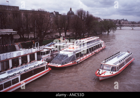 Moody grainy shot of some bateaux mouches tour boats on the river Seine in Paris France on a stormy day Stock Photo