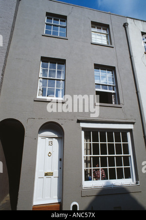 Terraced grey Victorian townhouse with white front door Stock Photo