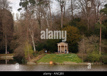 VISITORS IN THE GROUNDS OF BOWOOD HOUSE EXPLORE THE DORIC TEMPLE WHICH SITS BESIDE THE LAKE WILTSHIRE UK Stock Photo