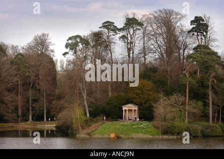 VISITORS IN THE GROUNDS OF BOWOOD HOUSE EXPLORE THE DORIC TEMPLE WHICH SITS BESIDE THE LAKE WILTSHIRE UK Stock Photo