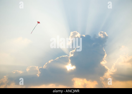 A red kite flying in front of a cloud Stock Photo