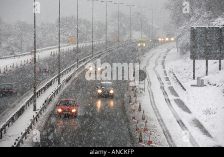 cars in traffic driving along the M2 motorway outside Belfast during heavy snowstorm Stock Photo