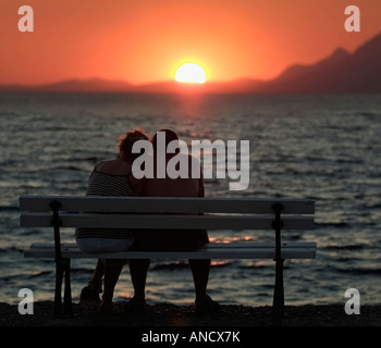 Couple Watching the Sunset over the Mediterranean Ocean Stock Photo