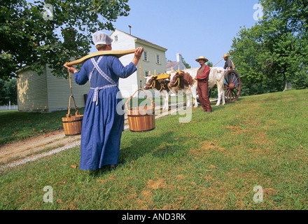 Local residents dress in traditional Shaker clothing as they go about a life of farming at the old restored Shaker town Stock Photo