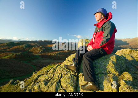 A walker enjoying the view from Loughrigg above Ambleside Lake District UK Stock Photo