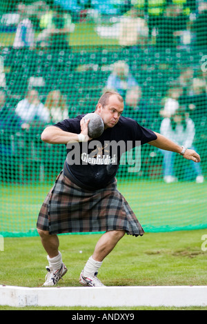 Man competes in shot put contest at the Braemar Games Highland Gathering Scotland UK Stock Photo