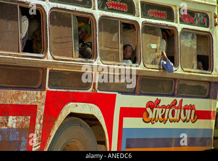 Colourful dirty local bus carry people woman child boy wait cross on raft Busisi Mwanza Lake Victoria Tanzania East Africa Stock Photo