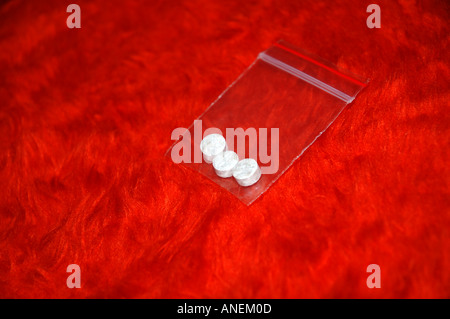 Party pills in plastic bag on faux fur background Stock Photo