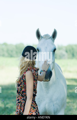 Young woman touching horse Stock Photo