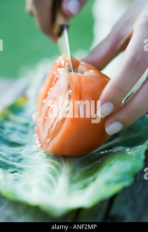 Woman cutting tomato, close-up Stock Photo
