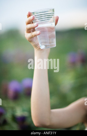 Woman holding up glass of water, cropped Stock Photo