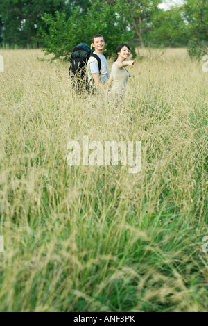 Young couple going for hike, woman pointing out of frame Stock Photo
