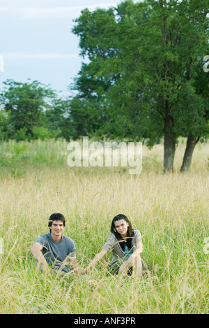 Young couple sitting in field Stock Photo
