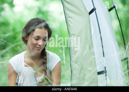 Young woman next to tent Stock Photo
