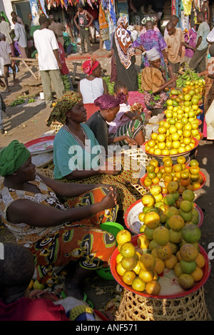 Peasant women in traditional colourful clothing sell citrus orange lemon banana fruit Namanga Southern Kenya East Africa Stock Photo